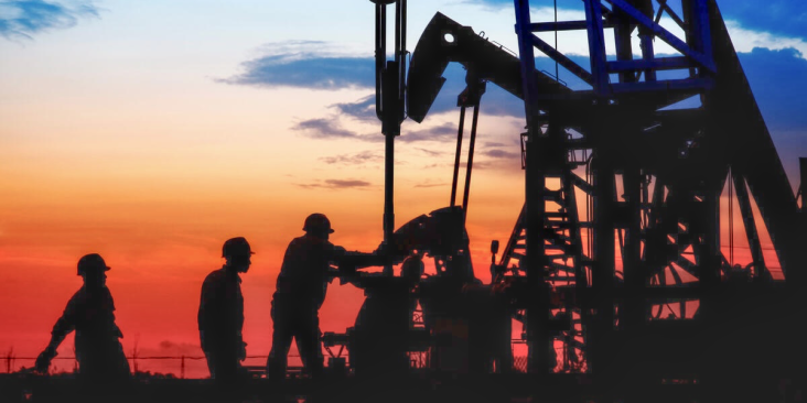 Gas well and workers at sunset